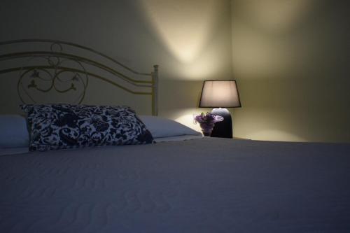 a bedroom with a bed with a pillow and a lamp at Artemis in Mirto Crosia