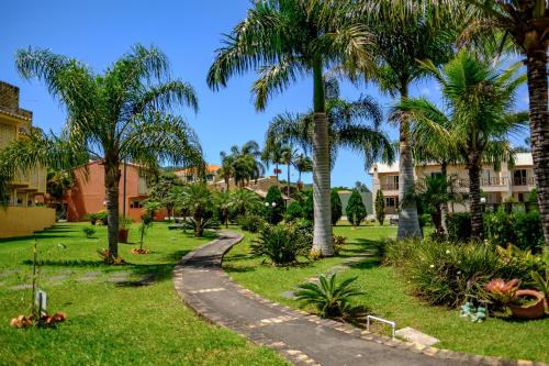 un camino sinuoso a través de un parque con palmeras en Villa Oliva Residence, en Florianópolis