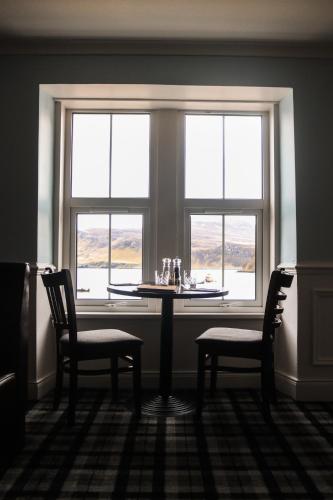 a table and two chairs in front of a window at The Rosedale Hotel & Restaurant in Portree