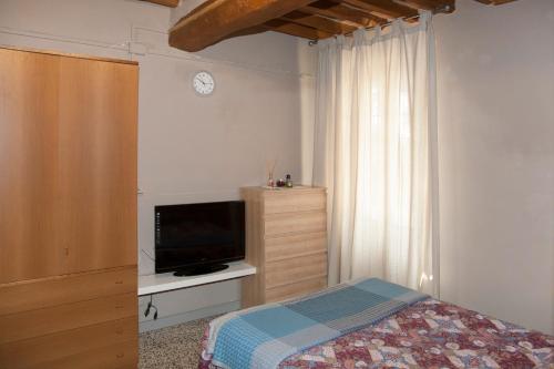 a bedroom with a bed and a flat screen tv at Agriturismo Dosso al Porto in Rolo