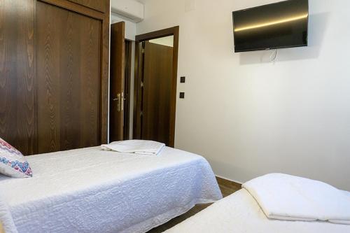 a bedroom with two beds and a tv on the wall at Alojamientos Rurales Entre Rocas in Ayna