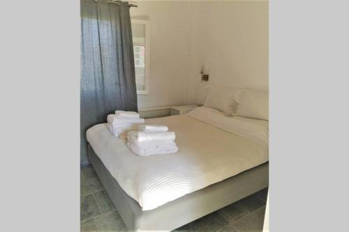 1 dormitorio con 1 cama con toallas en Phylakopi House, en Pachaina