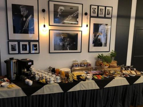 a table with food on it with pictures on the wall at ART Pensjonat in Krotoszyn