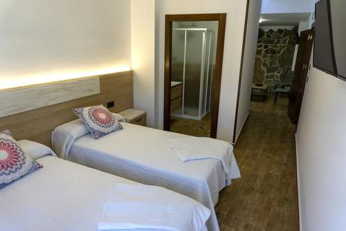 a hotel room with two beds and a mirror at Alojamientos Rurales Entre Rocas in Ayna