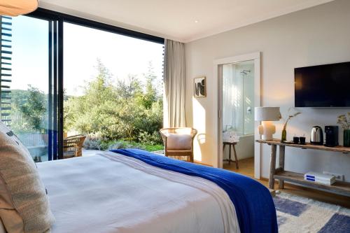 a bedroom with a bed and a large window at Domaine de Peretti della Rocca in Figari