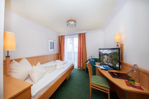 a hotel room with a bed and a desk at Der Schütthof in Zell am See