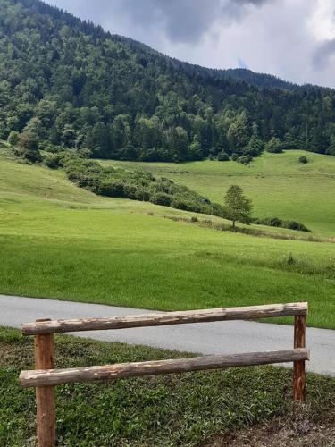 a wooden bench sitting on the side of a road at Apartma LUPIS in Podvolovljek