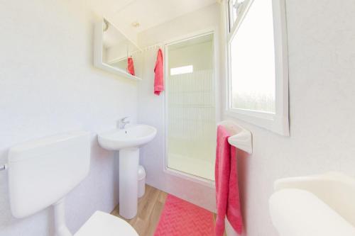 a white bathroom with a sink and a toilet at Scandinavian lodge in Zuna