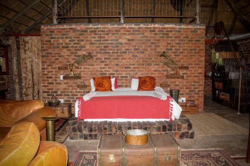 a brick room with a bed in a brick wall at The Ancient Copper Shed in Potchefstroom