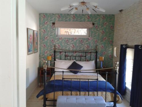 ein Schlafzimmer mit einem Bett und einer grünen Wand in der Unterkunft The Piggeries at La Maison Tumtum Arbre in Loudun