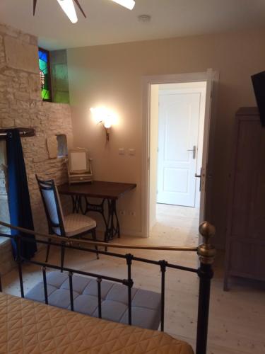 a room with a table and a desk and a door at The Piggeries at La Maison Tumtum Arbre in Loudun