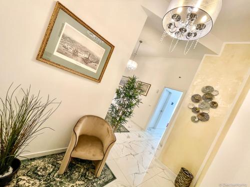 a hallway with a chair and a chandelier at The Gallery Boutique Rooms in Trieste