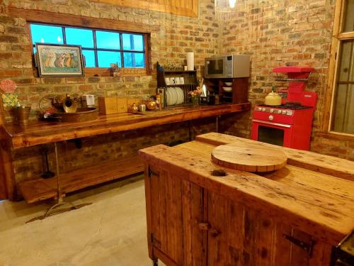 a kitchen with a wooden counter and a red stove at The Ancient Copper Shed in Potchefstroom