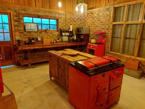 a kitchen with a red island in a room at The Ancient Copper Shed in Potchefstroom