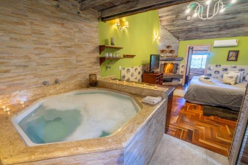 uma banheira de hidromassagem numa sala com um quarto em Pousada Alto Da Boa Vista em Campos do Jordão