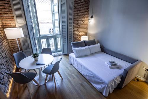 a small room with a bed and a table with chairs at Atlas in Málaga