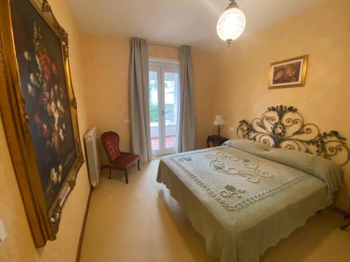 een slaapkamer met een bed en een groot raam bij Appartamenti in villa con piscina in Marina dʼAndora