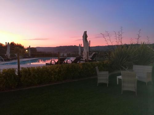 a sunset with a statue next to a swimming pool at B&B CasalFarano in Cupra Marittima