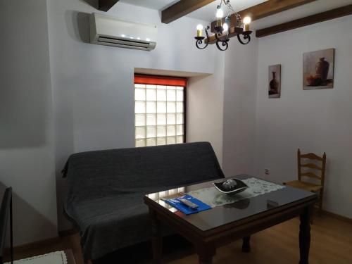 a room with a bed and a table and a window at Alojamientos Turísticos Delgado in Úbeda