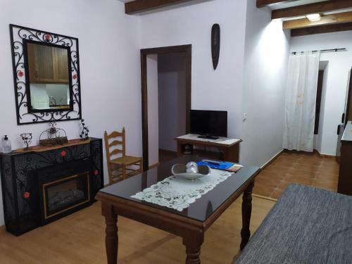 a living room with a table and a fireplace at Alojamientos Turísticos Delgado in Úbeda