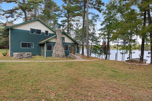 a blue house on the shore of a lake at Stone Lake View in Manitowish Waters