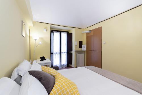 a bedroom with a bed with white sheets and pillows at Nizza Studio Apartments by Wonderful Italy in Turin