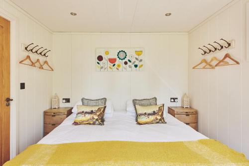 a bedroom with a large white bed with two pillows at Woodland Cabin in Upton upon Severn