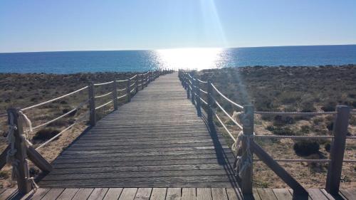 a wooden boardwalk leading to the ocean on a beach at Apartamento Salgados Beach in Albufeira