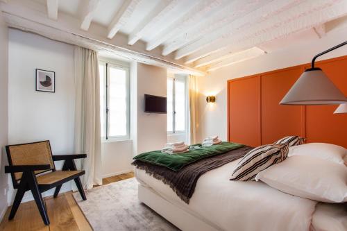 une chambre avec un grand lit et une chaise dans l'établissement Cozy Apartment -2BR-6P- Cathédrale de Notre-Dame, à Paris