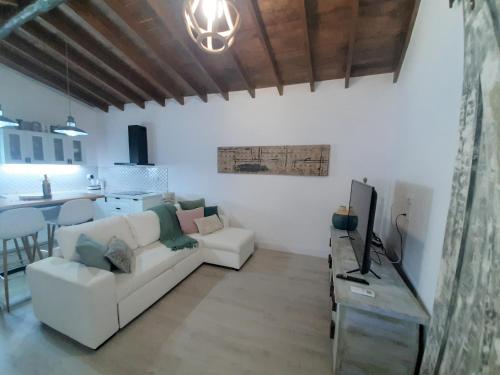 a living room with a white couch and a tv at Villa Aura in La Sorrueda