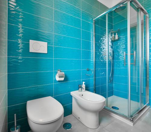 een blauwe badkamer met een toilet en een douche bij Blue Sky Sorrento Apartment FREE PARKING in Meta