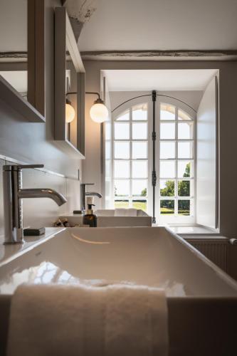 une cuisine avec un grand évier et une fenêtre dans l'établissement Chateau de St MACLOU, à Saint-Maclou