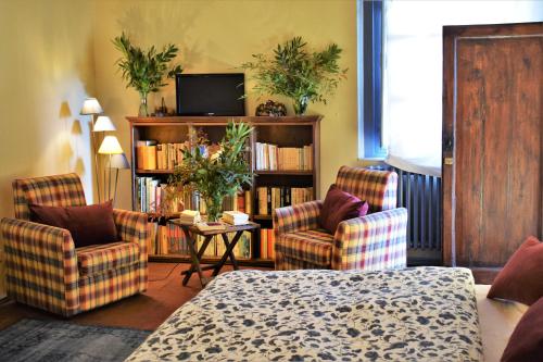 a living room with two chairs and a tv at Al Carmine Apartments Towers view with AC in Lucca