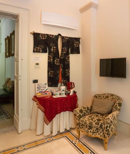 a living room with a table and a chair at Palazzo Rollo in Lecce