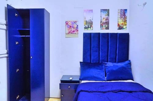 a bedroom with a blue bed with a blue headboard at My place agata Hostel in Cairo