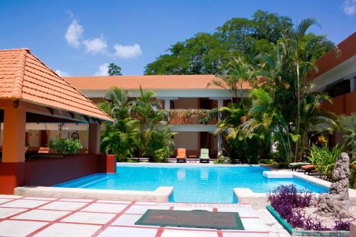 a swimming pool in front of a building at Villas Arqueologicas Chichen Itza in Chichén-Itzá