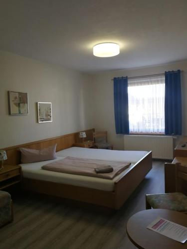ein Schlafzimmer mit einem großen Bett und einem Fenster in der Unterkunft Hotel Waldidyll in Eggesin