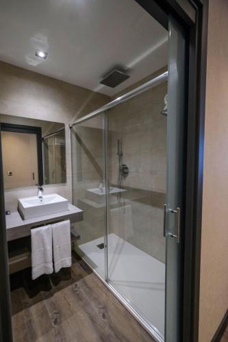 a bathroom with a glass shower and a sink at LD Sevilla in Guillena