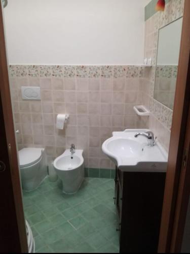 łazienka z 2 umywalkami i toaletą w obiekcie Casa la Corte w mieście Parabita