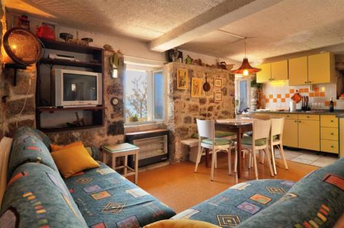 een woonkamer met een bank en een keuken met een tafel bij Old, stone 2 floor house above the sea-Najka in Pisak
