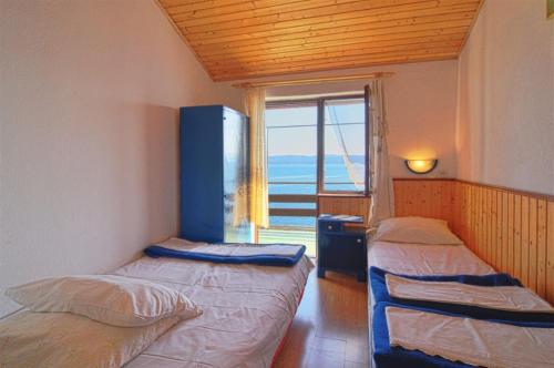 twee bedden in een kamer met een raam bij Old, stone 2 floor house above the sea-Najka in Pisak