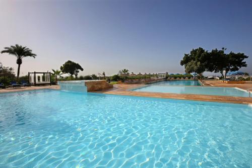 a large swimming pool with blue water at Anezi Tower Hotel in Agadir