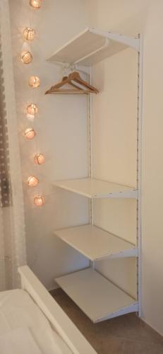 a closet with white shelves and lights on the wall at Casa Dikella in Mesimvría