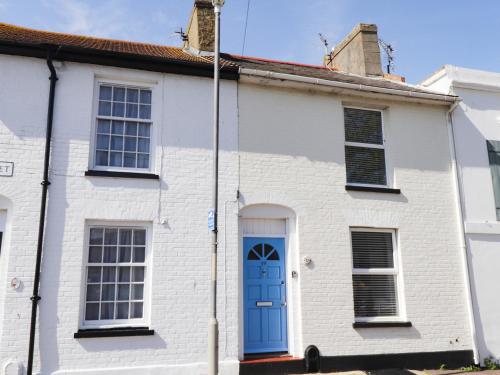 a white house with a blue door at Poppy Cottage in Deal