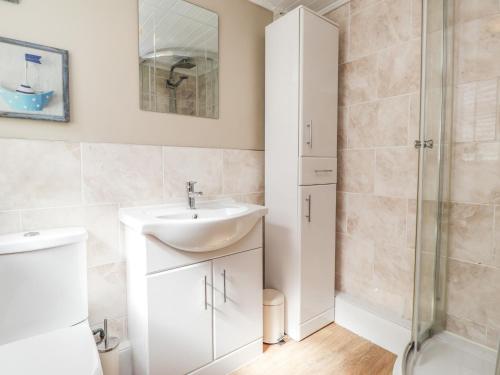 a bathroom with a sink and a shower at Poppy Cottage in Deal