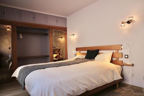 um quarto com uma cama grande e lençóis brancos em COTTAGE ON THE CANAL em Kortrijk