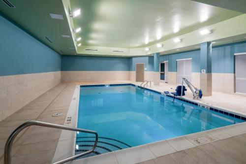 a large swimming pool in a building with blue walls at Holiday Inn Express & Suites - St Peters by IHG in Saint Peters