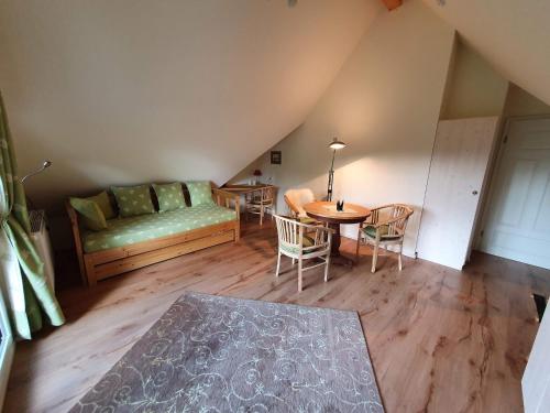 a living room with a couch and a table and chairs at Pension am Kirschgarten in Gößweinstein