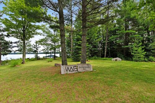 a sign in the grass next to a tree at Grand Tomahawk Lodge in Tomahawk