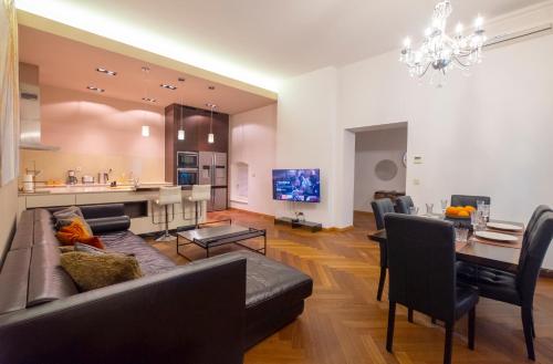 a living room with a couch and a dining room at Address Deluxe Downtown in Ljubljana